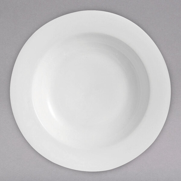 A Chef & Sommelier white bone china bowl with a white rim on a gray surface.