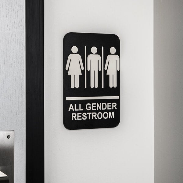 A black and white Tablecraft sign that says "All Gender Restroom" with Braille on a wall.