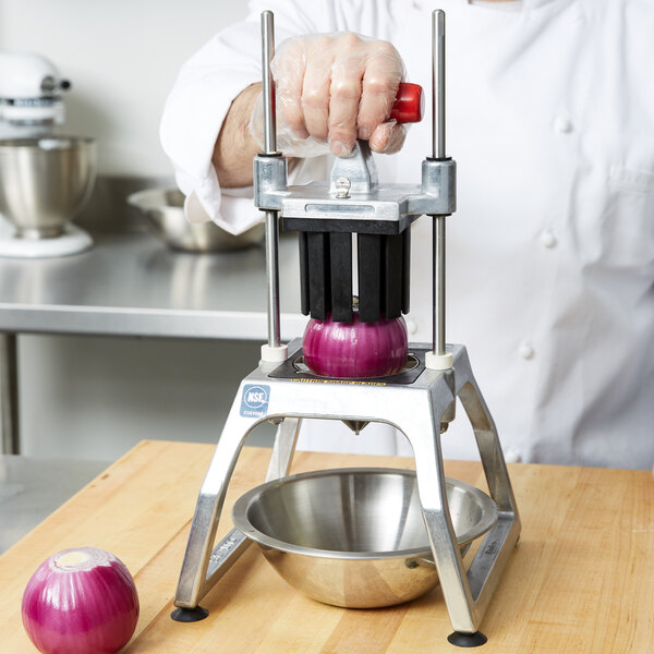A chef using a Vollrath Redco InstaCut 3.5 to wedge a red onion.