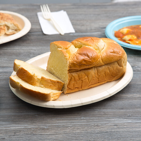 An ivory oval paper platter with sliced bread on it.