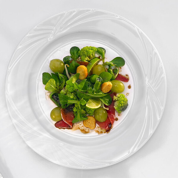 An Arcoroc white porcelain brunch plate with salad, grapes, and broccoli on it.