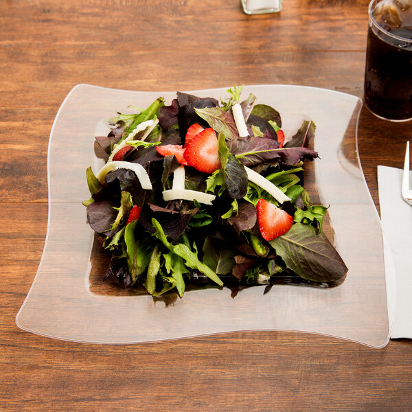 A salad on a Fineline clear plastic square plate.