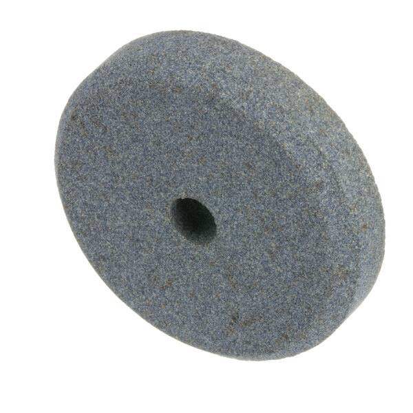 A grey circular grinding stone with a hole in the center.