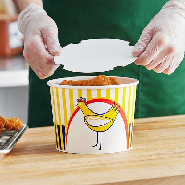 A person holding a Choice 64 oz. chicken bucket filled with fried chicken.