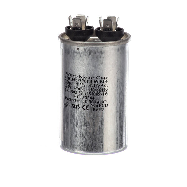 A round metal capacitor with black text.