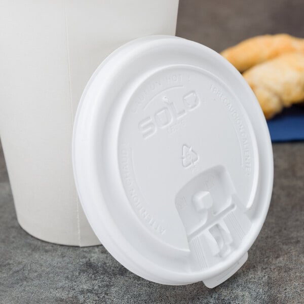 A Solo white plastic tab lid on a white paper cup.