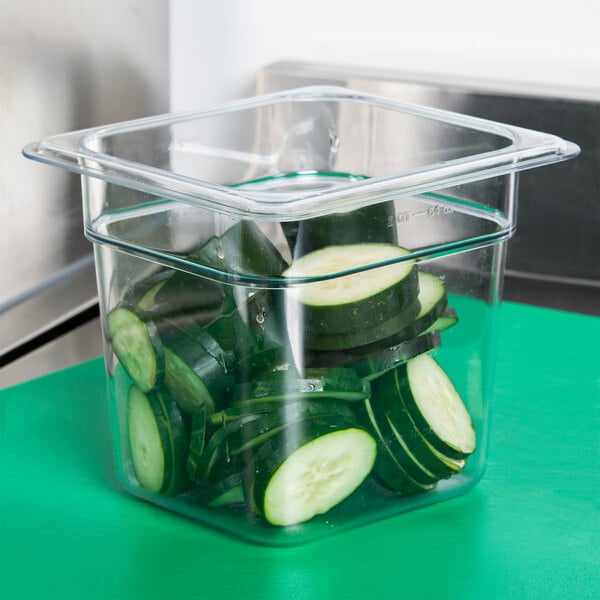 A Carlisle clear plastic food pan with cucumbers in it.