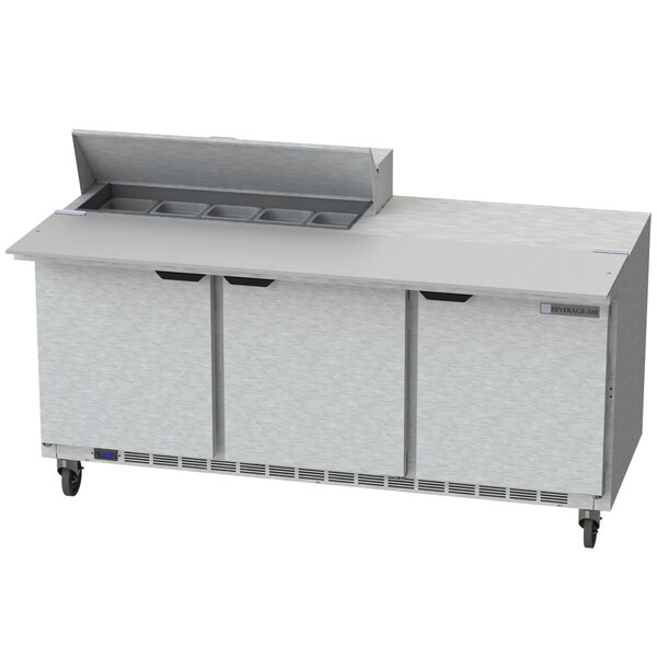 A Beverage-Air stainless steel 3 door sandwich prep table on wheels with a cutting board.