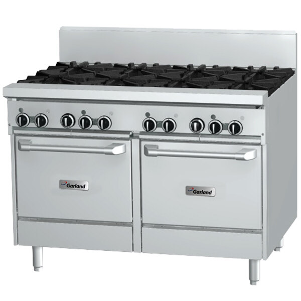 A white Garland commercial gas range with black knobs on the burners.