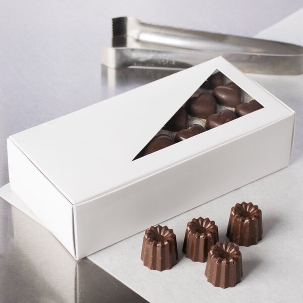 A white 1 lb. candy box with chocolates and a knife.