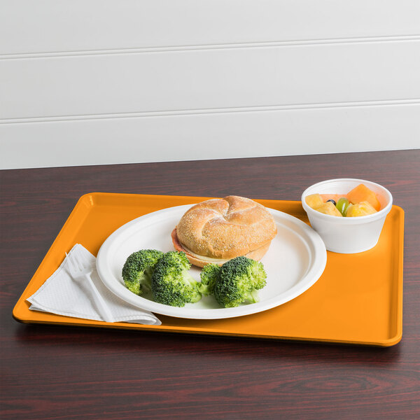 A mustard Cambro dietary tray with a plate of food including broccoli.