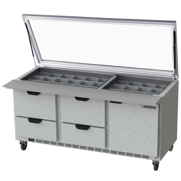 A Beverage-Air stainless steel refrigerated sandwich prep table with a glass lid open over four drawers.