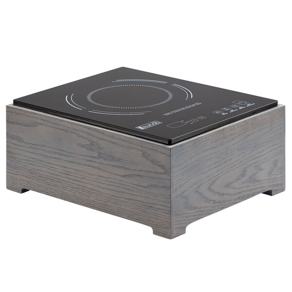 A black and grey Cal-Mil Ashwood countertop induction cooker on a wooden stand.