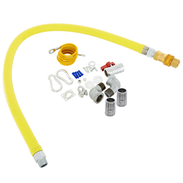 A yellow T&S gas hose kit with various parts including elbows, nipples, a restraining cable, and a ball valve.