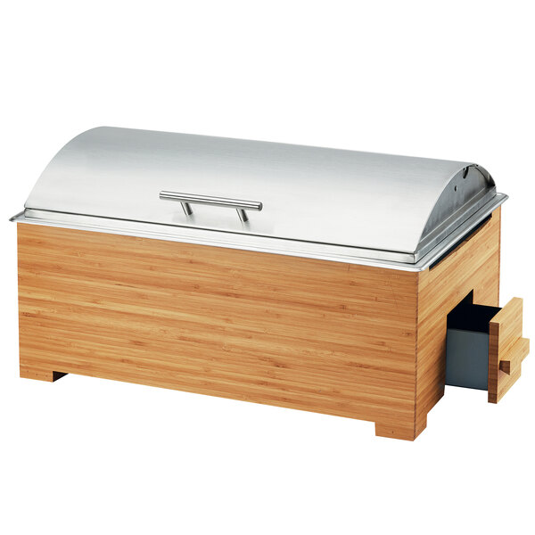 A bamboo chafer with a silver lid on a table in an outdoor catering setup.