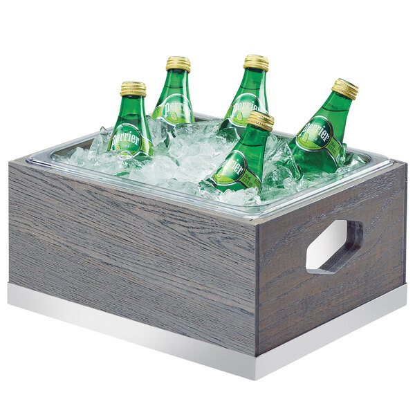 A wooden Cal-Mil ice housing with green bottles in it.