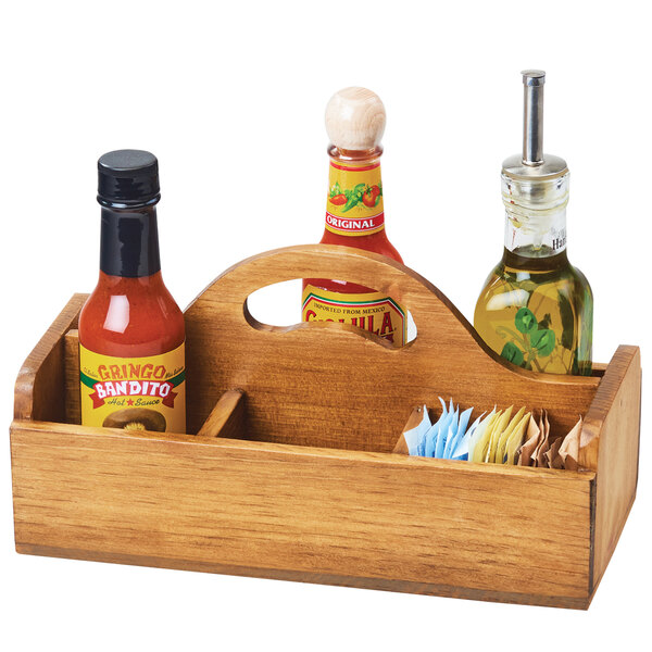 A Cal-Mil Madera wooden condiment caddy with sections holding hot sauces and condiments.