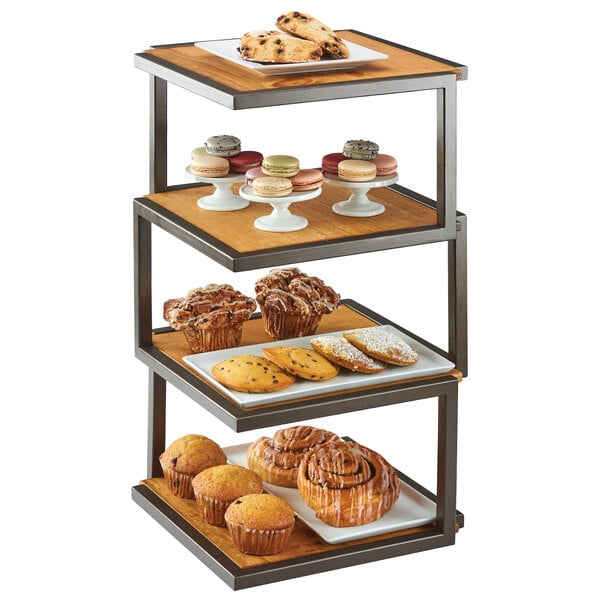 A Cal-Mil Sierra bronze metal and rustic pine 4-tier elevation riser with various pastries and muffins on it.