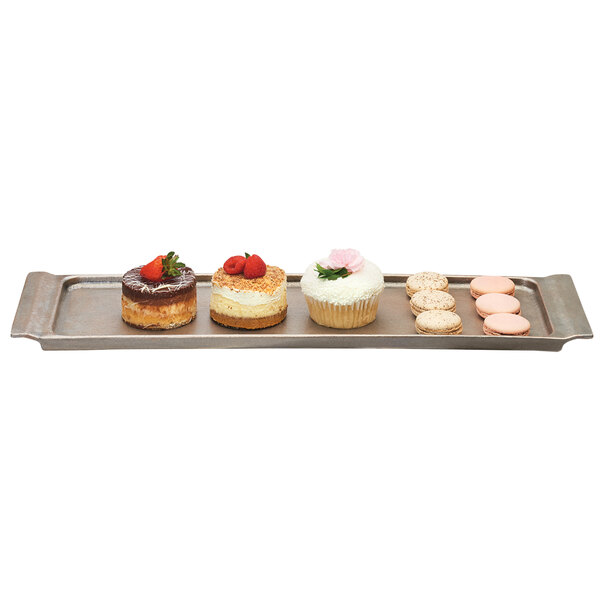 An aluminum Cal-Mil serving platter with a cheesecake, cupcake, and other desserts.