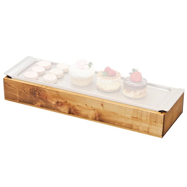 A Cal-Mil Madera wood frame with cold pack and liner holding cupcakes and cookies on a table.