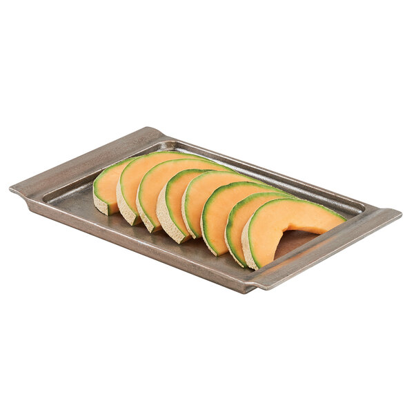 A Cal-Mil aluminum platter with sliced melons on it.