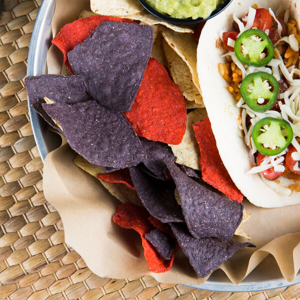 A plate with a taco and Mission Tri-Color Triangle Corn Tortilla Chips on a table.