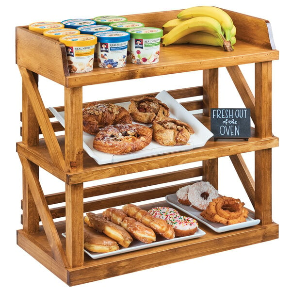 A Cal-Mil Madera rustic pine wood shelf with food on it.