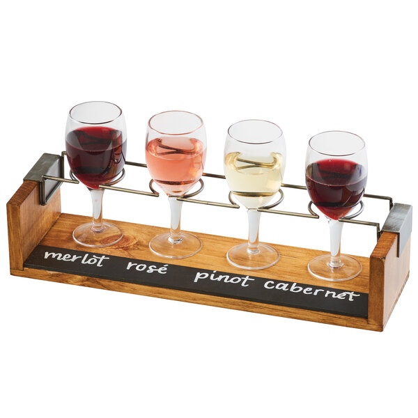 A Cal-Mil Industrial wine tasting flight with three wine glasses on a wooden tray with a chalkboard.