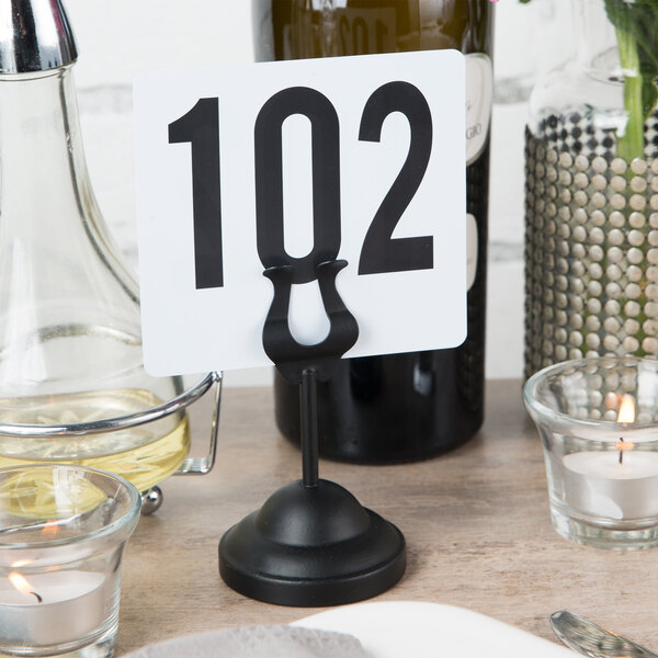 An American Metalcraft black harp table card holder with a table number on it.