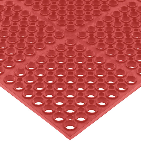 A red San Jamar Tuf-Mat with holes in the middle.