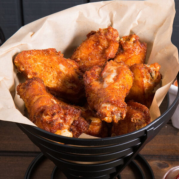 A black bowl filled with Tyson oven roasted chicken wing sections.