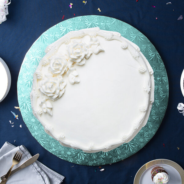A white cake with frosting on a blue Enjay round cake drum.