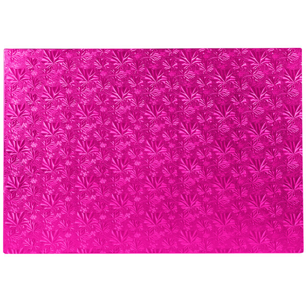 A pink cake board with a patterned surface.