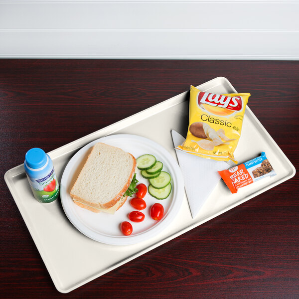 A Cambro tray with a sandwich, chips, and a drink on it.