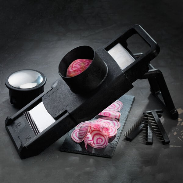 A black Matfer Bourgeat vegetable slicer with a red onion in a bowl on a black surface.