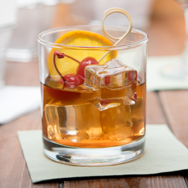 An Anchor Hocking Concord rocks glass with ice, whiskey, and orange and cherry garnish.