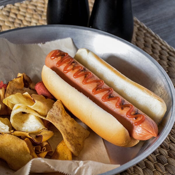 A Gonnella Baking Company hot dog in a bun with ketchup and chips on a plate.