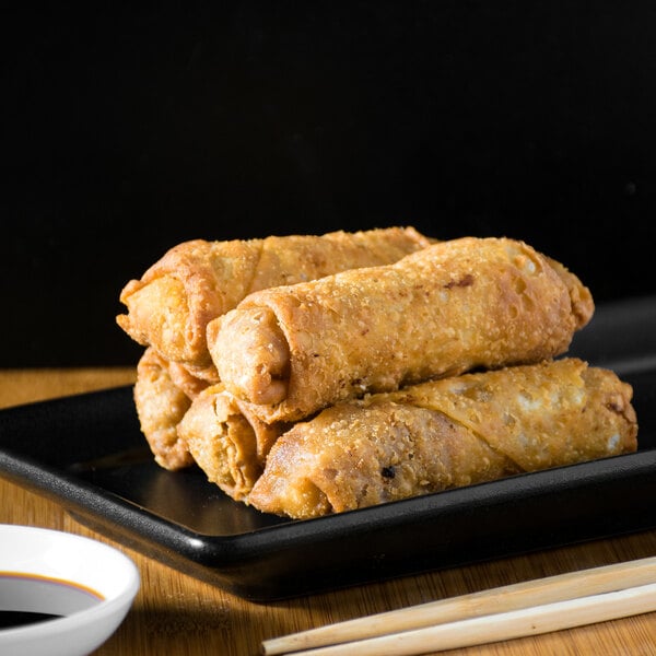 A white plate with close-up of fried Original Philly Beef Cheesesteak Egg Rolls.