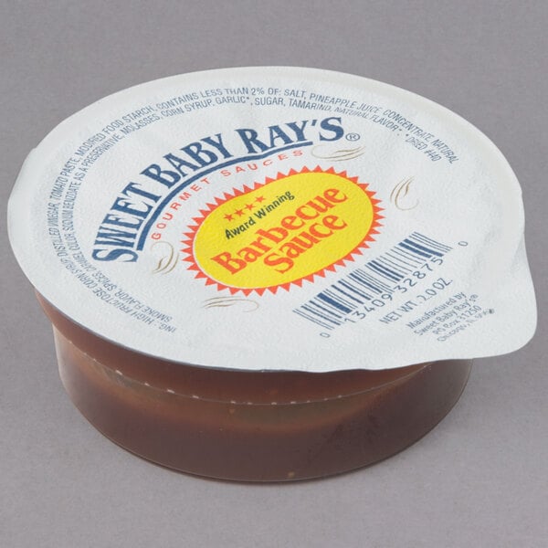 A close-up of a Sweet Baby Ray's BBQ sauce dipping cup.