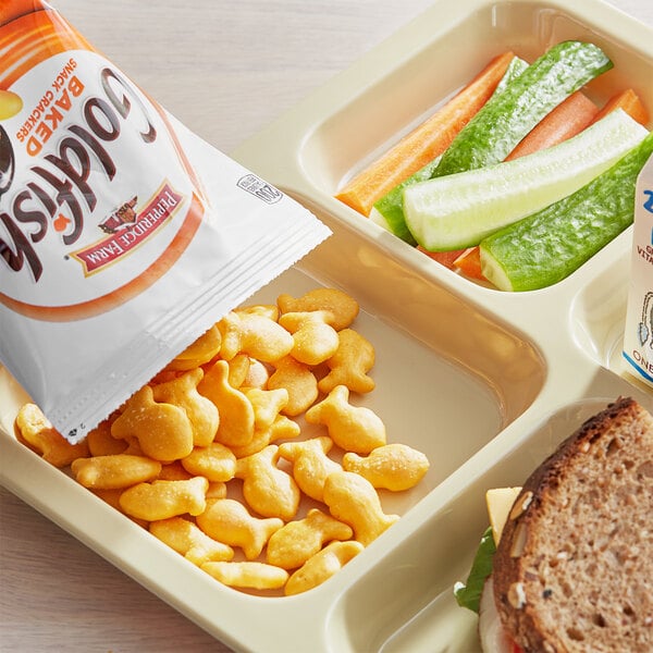 A tray of food with a bag of Pepperidge Farm Goldfish crackers and vegetables.