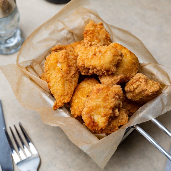 A table with a basket of Brakebush Doo-Wa Ditties boneless breaded chicken wing fritters.