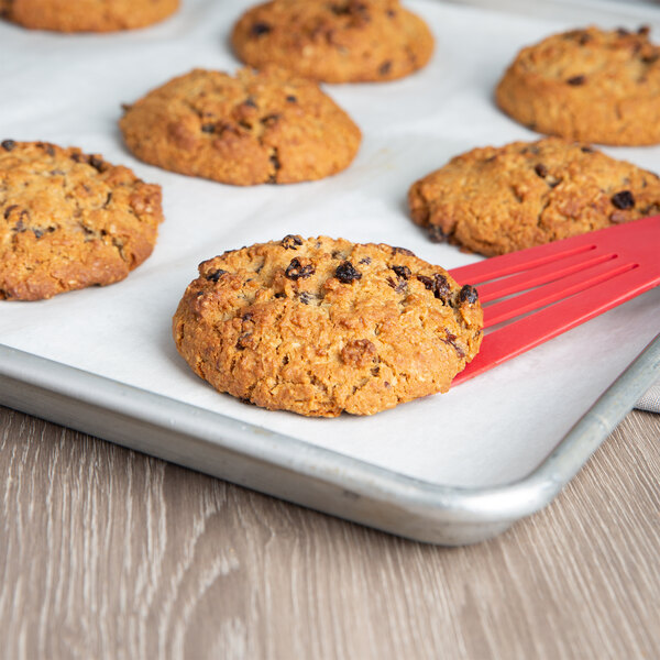 Preformed David's Cookies oatmeal raisin cookie on a red spatula over a tray.