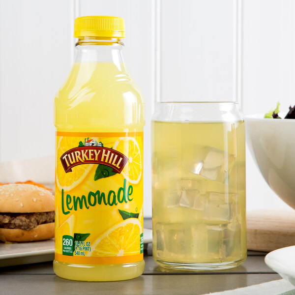 A bottle of Turkey Hill Lemonade next to a glass of yellow liquid with ice.