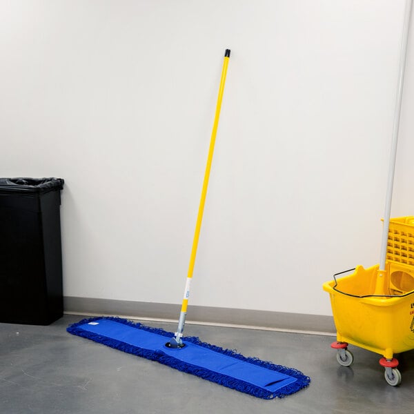A black rectangular Lavex All-In-One Microfiber Dust Mop with a yellow handle next to a yellow bucket.