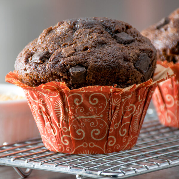 A close up of a chocolate muffin in a red Enjay baking cup.