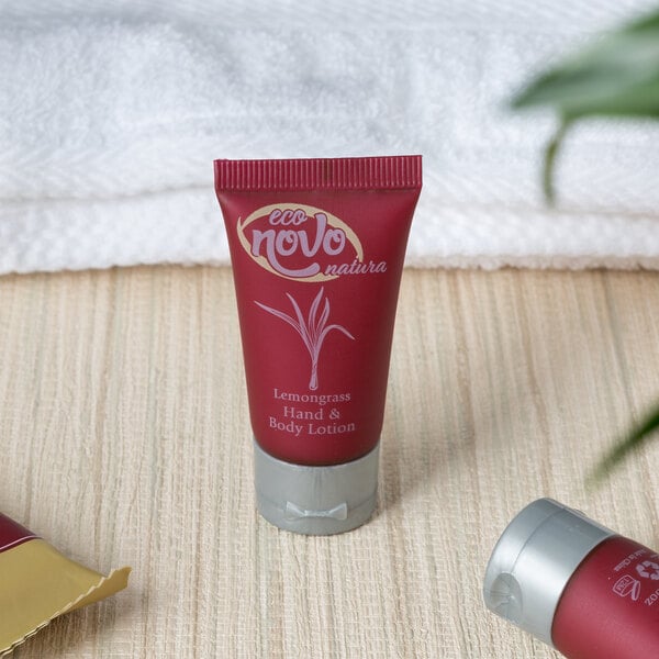 A group of small red Noble Eco Novo Natura lotion containers with white text.