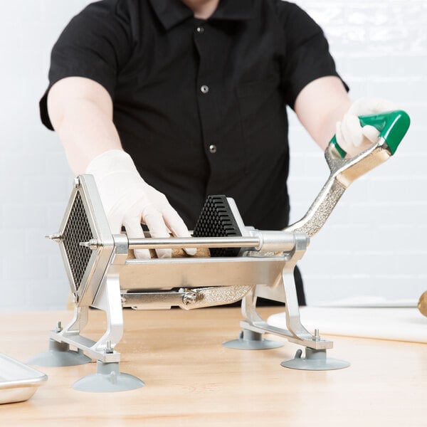 A person using a Garde French Fry Cutter to cut potatoes on a counter.