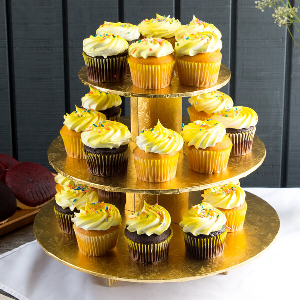 An Enjay gold cupcake stand with yellow cupcakes with yellow frosting and sprinkles.