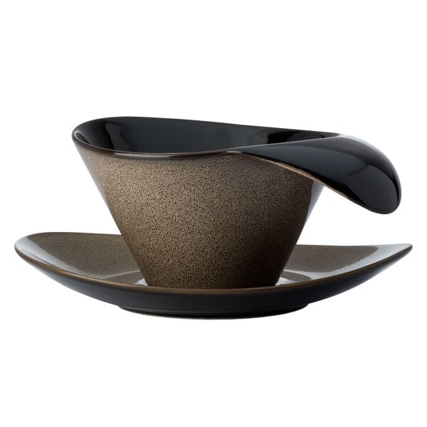 A brown and black Oneida Rustic porcelain teacup with a lip handle.