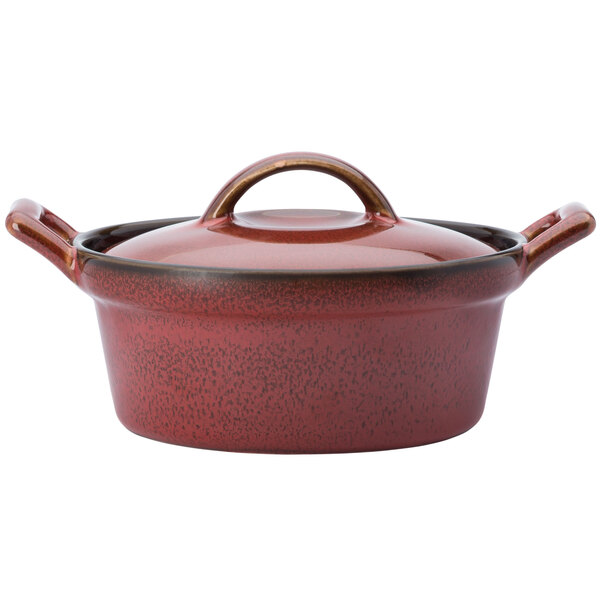 A crimson porcelain casserole dish with a lid and handle.